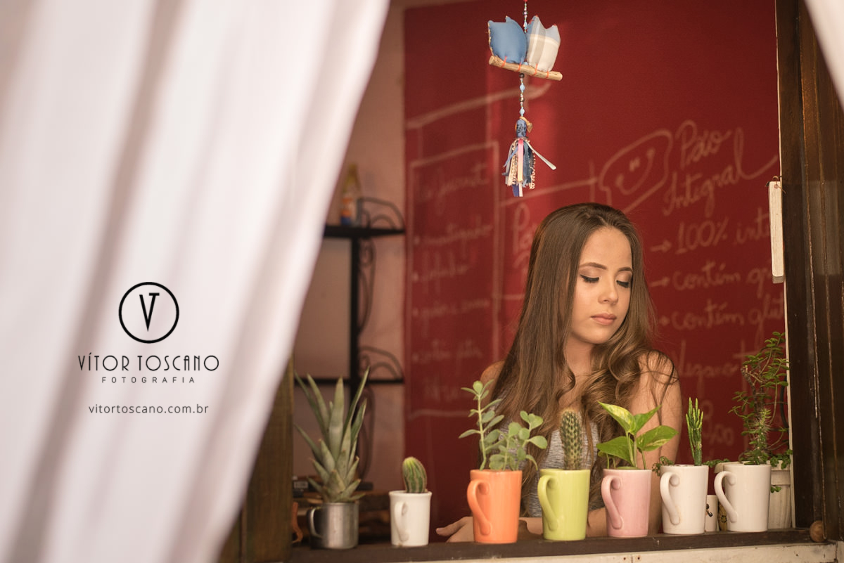 Debutante na janela no ensaio de debutante de Fernanda Araujo no Nuh Café e Boutique dos Pães, em Natal-RN.