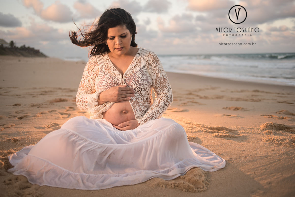 Gestante sentada na areia no ensaio de gestante de jane, em natal-rn.