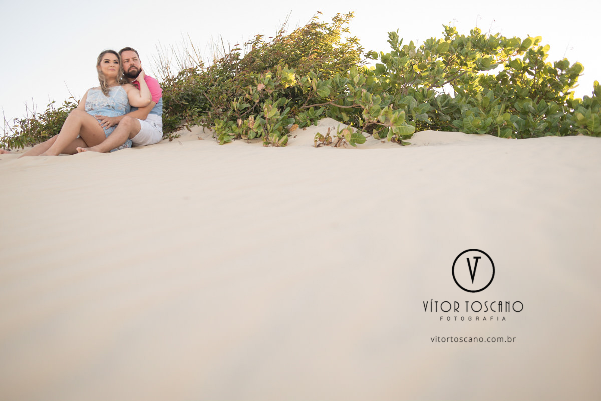Casal sentado na areia  no ensaio de casal de priscila e eudes, em muriu-rn.