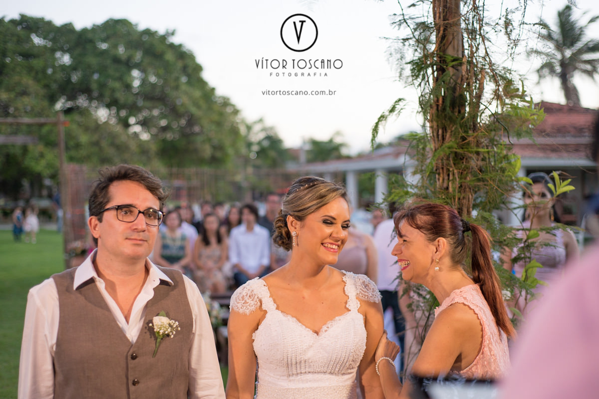 Noiva sorrindo com o cerimonial no casamento de Marilia e Jornandis, em Natal-RN.