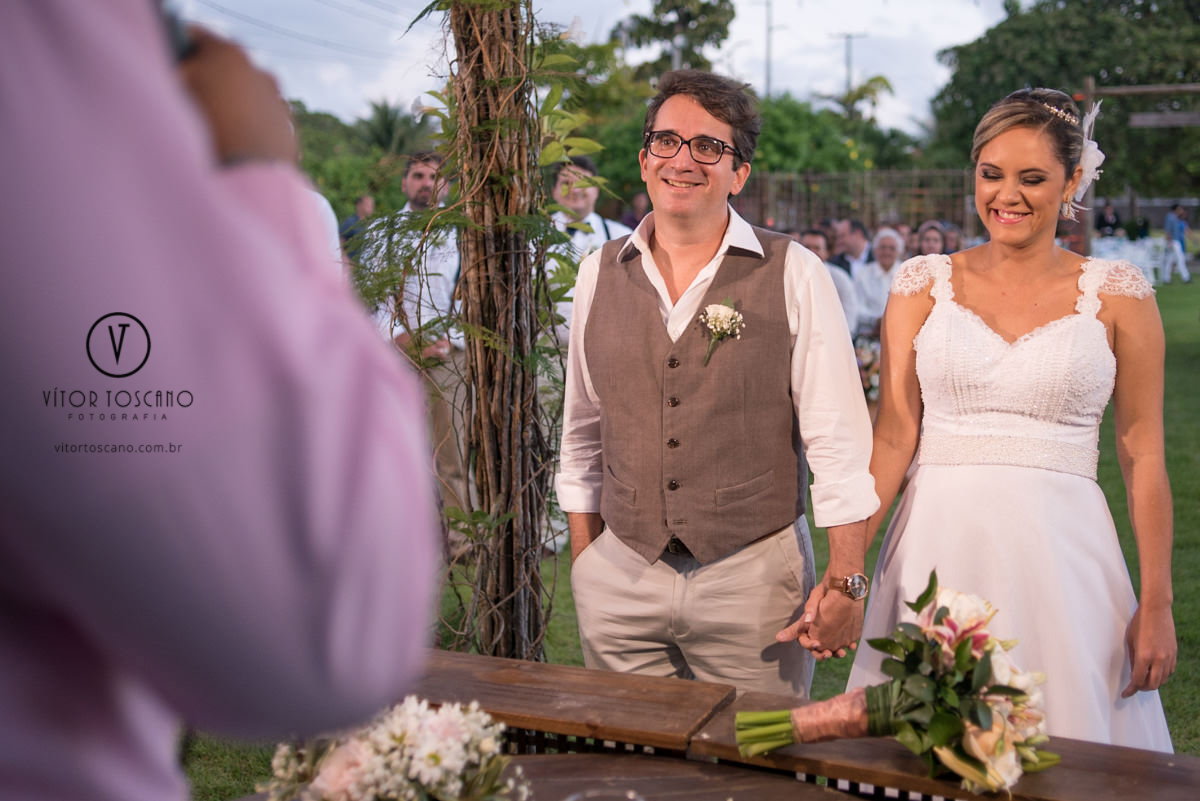 Noivos juntos no altar no casamento de Marilia e Jornandis, em Natal-RN.