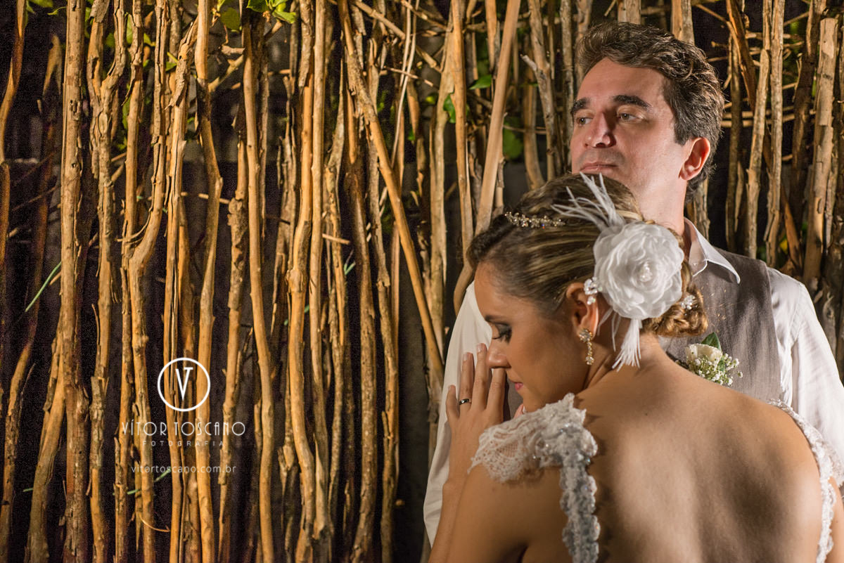 Casal na cerca na sessão de fotos no casamento de Marilia e Jornandis, em Natal-RN.