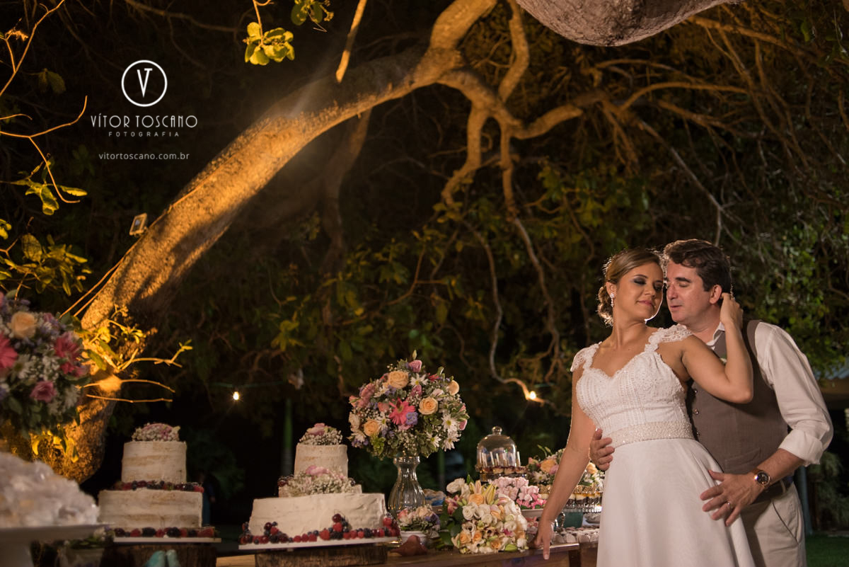 Casal na mesa de doces na sessão de fotos no casamento de Marilia e Jornandis, em Natal-RN.