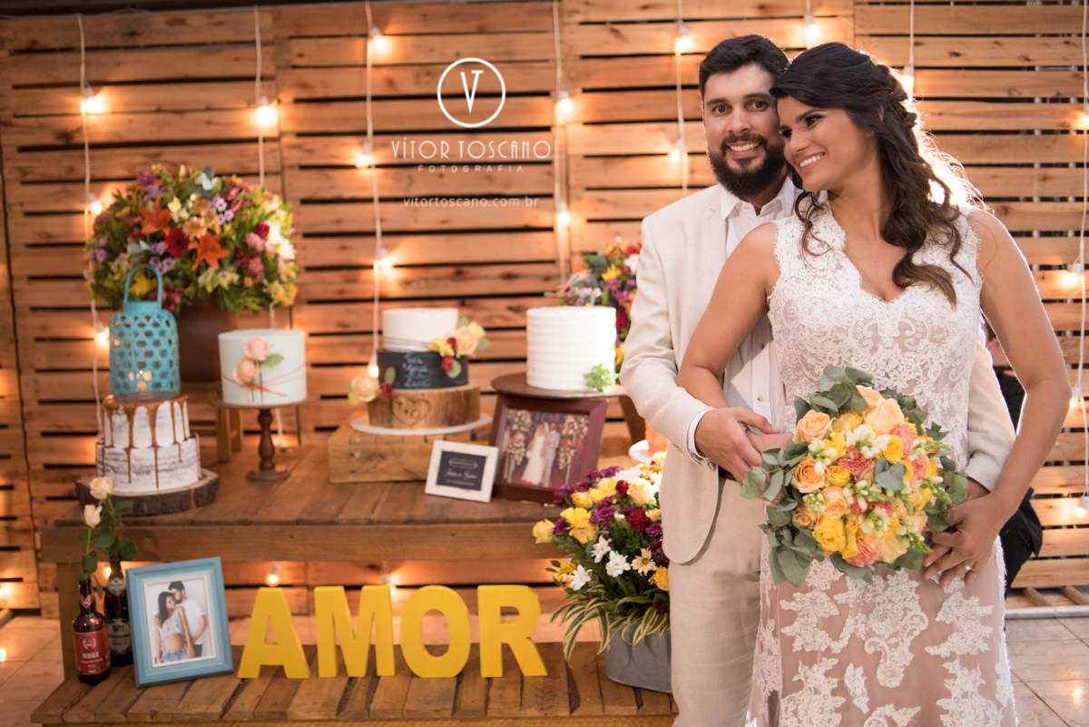 Casal em frente ao bolo no casamento de Tici e Guga, em Natal-RN.