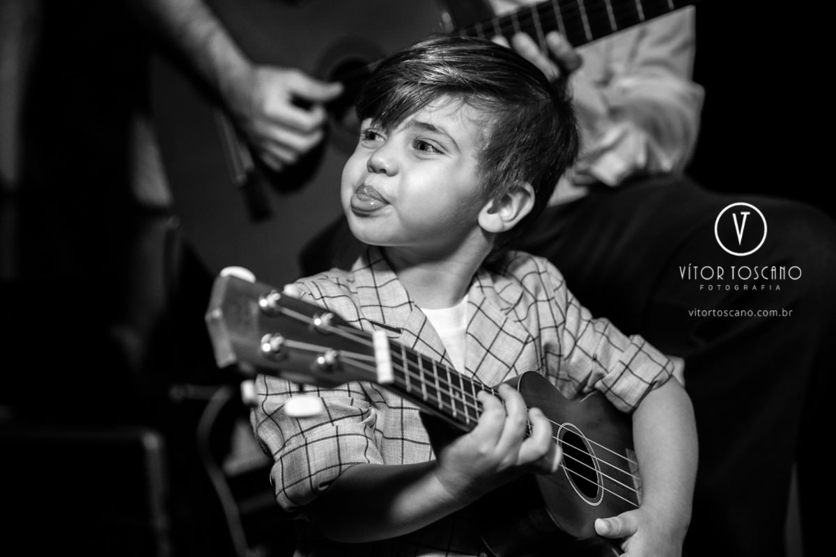 Criança tocando violão no casamento de Tici e Guga, em Natal-RN.