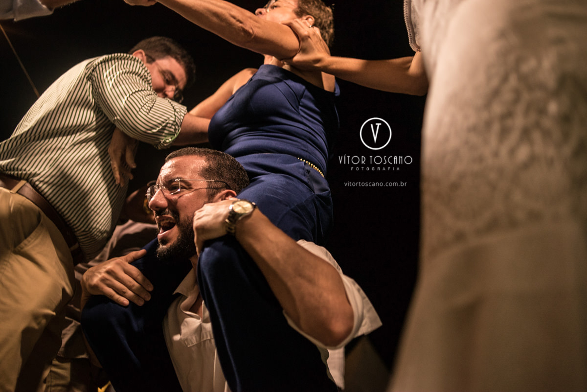 Mulher subindo nas costas do homem no casamento de Tici e Guga, em Natal-RN.