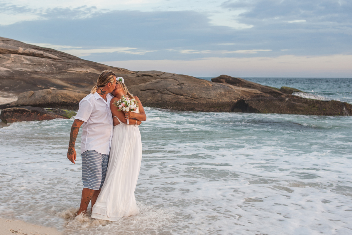 Elopement Wedding, casamento a dois em Saquarema, luz natural, beijo dos noivos na praia ao lado da igreja Paróquia Nossa Senhora de Nazareth
