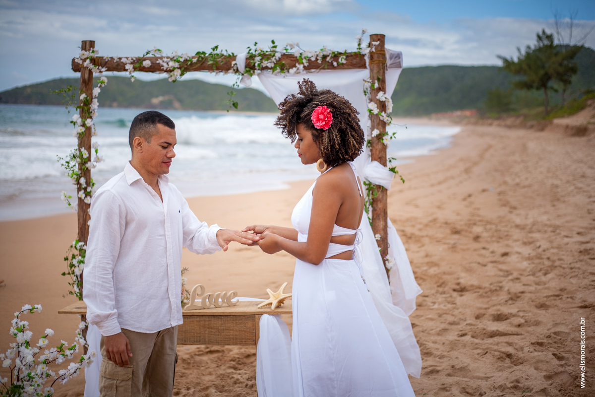 Foto dos noivos trocando as alianças em Elopement Wedding na praia de tucuns em búzios