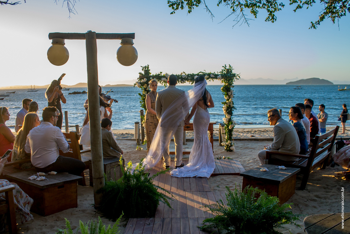 Foto dos noivos na troca de votos e alianças no casamento no restaurante Dona Jô no Porto da Barra em Búzios