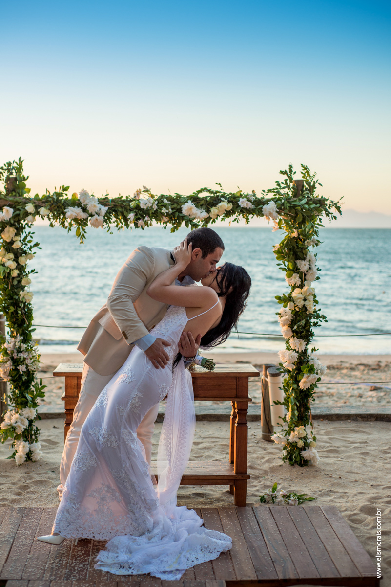 Foto do beijo dos noivos no casamento no restaurante Dona Jô no Porto da Barra em Búzios