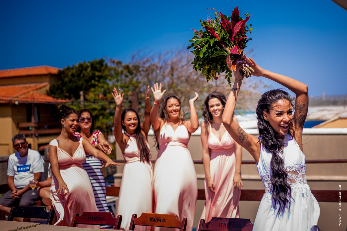 noiva jogando o bouquet após casamento na Praia do Foguete em Cabo Frio - RJ