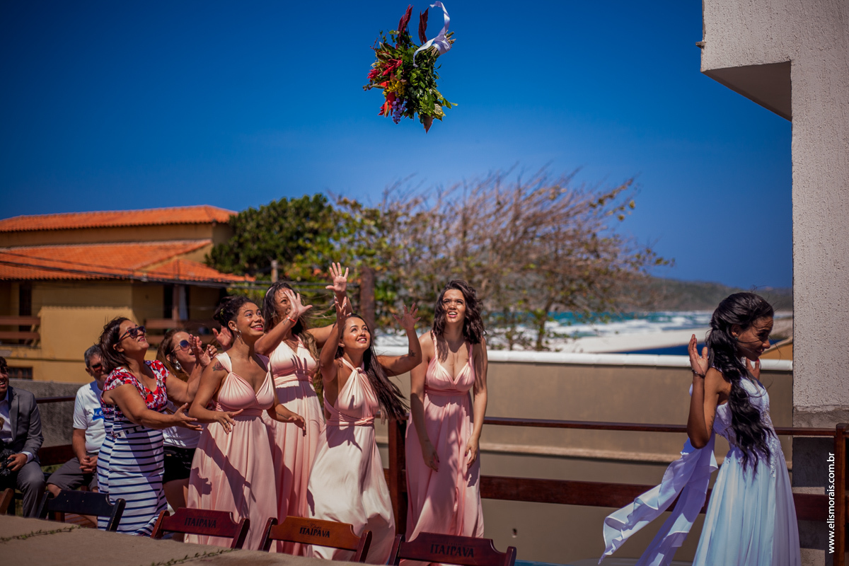 noiva jogando o bouquet após casamento na Praia do Foguete em Cabo Frio - RJ