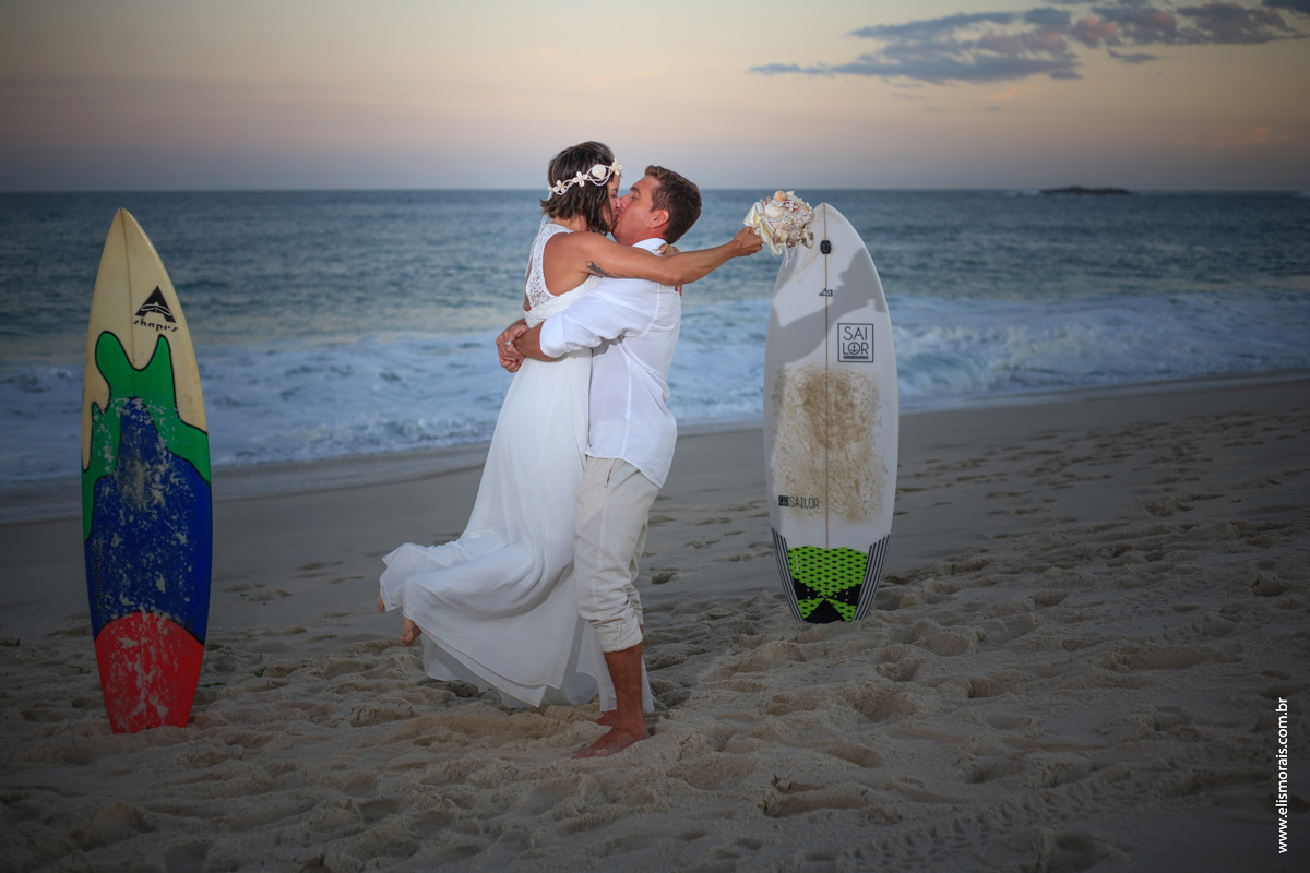 fotos do ensaio fotográfico dos noivos com pranchas de surf ao por do sol no elopement wedding na Praia de Itaúna em Saquarema - RJ. 
