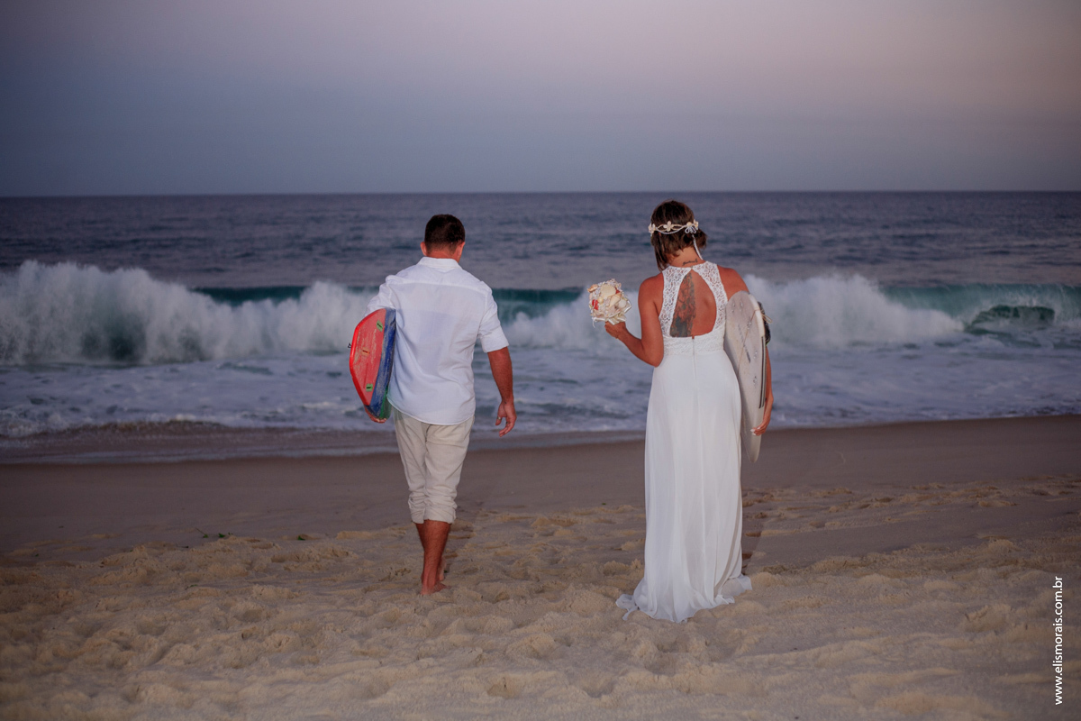 fotos do ensaio fotográfico dos noivos com pranchas de surf ao por do sol no elopement wedding na Praia de Itaúna em Saquarema - RJ. 