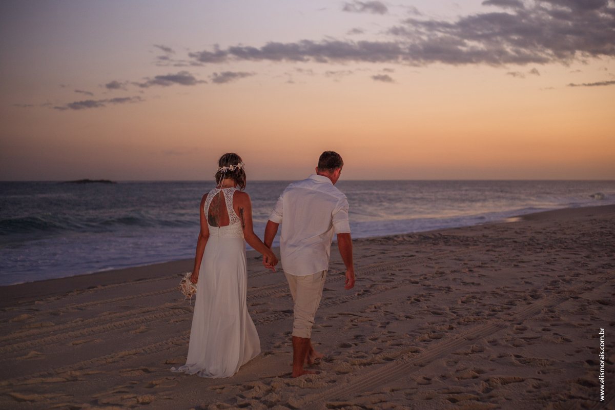 fotos do ensaio fotográfico dos noivos com pranchas de surf ao por do sol no elopement wedding na Praia de Itaúna em Saquarema - RJ. 