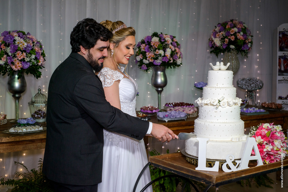 fotografia do corte do bolo dos noivos  na festa de casamento na Mansão das Orquídeas Casa de Festas em Araruama - RJ