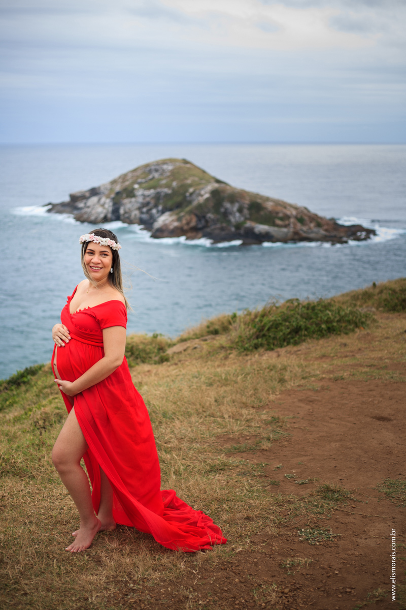 Foto no mirante da Praia Grande do ensaio fotográfico gestante vestindo vermelho em Arraial do cabo - RJ