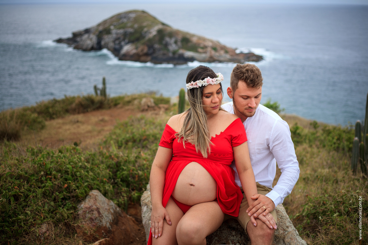 Foto no mirante da Praia Grande do ensaio fotográfico gestante vestindo vermelho em Arraial do cabo - RJ