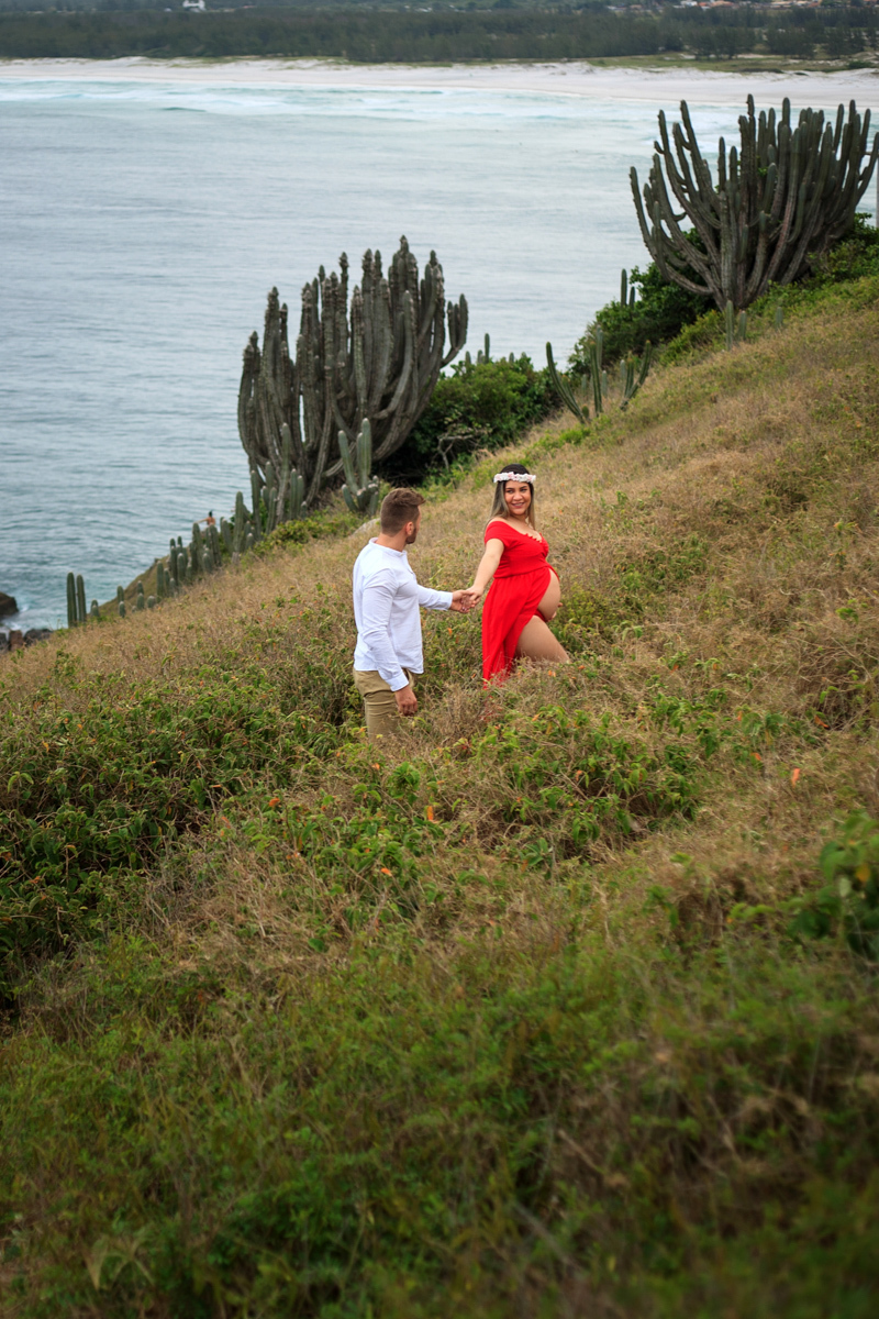 Foto no mirante da Praia Grande do ensaio fotográfico gestante vestindo vermelho em Arraial do cabo - RJ
