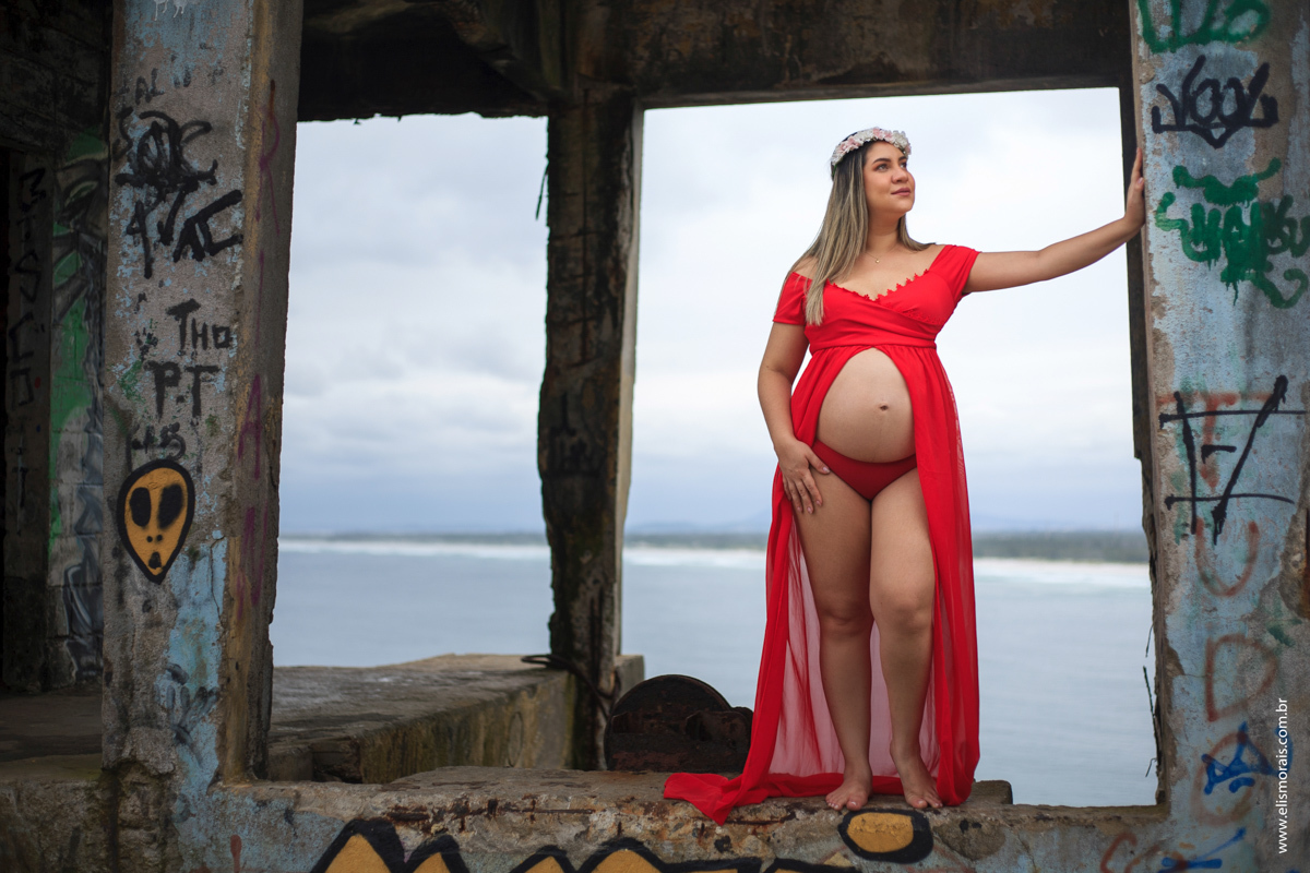 Foto no mirante da Praia Grande do ensaio fotográfico gestante vestindo vermelho em Arraial do cabo - RJ