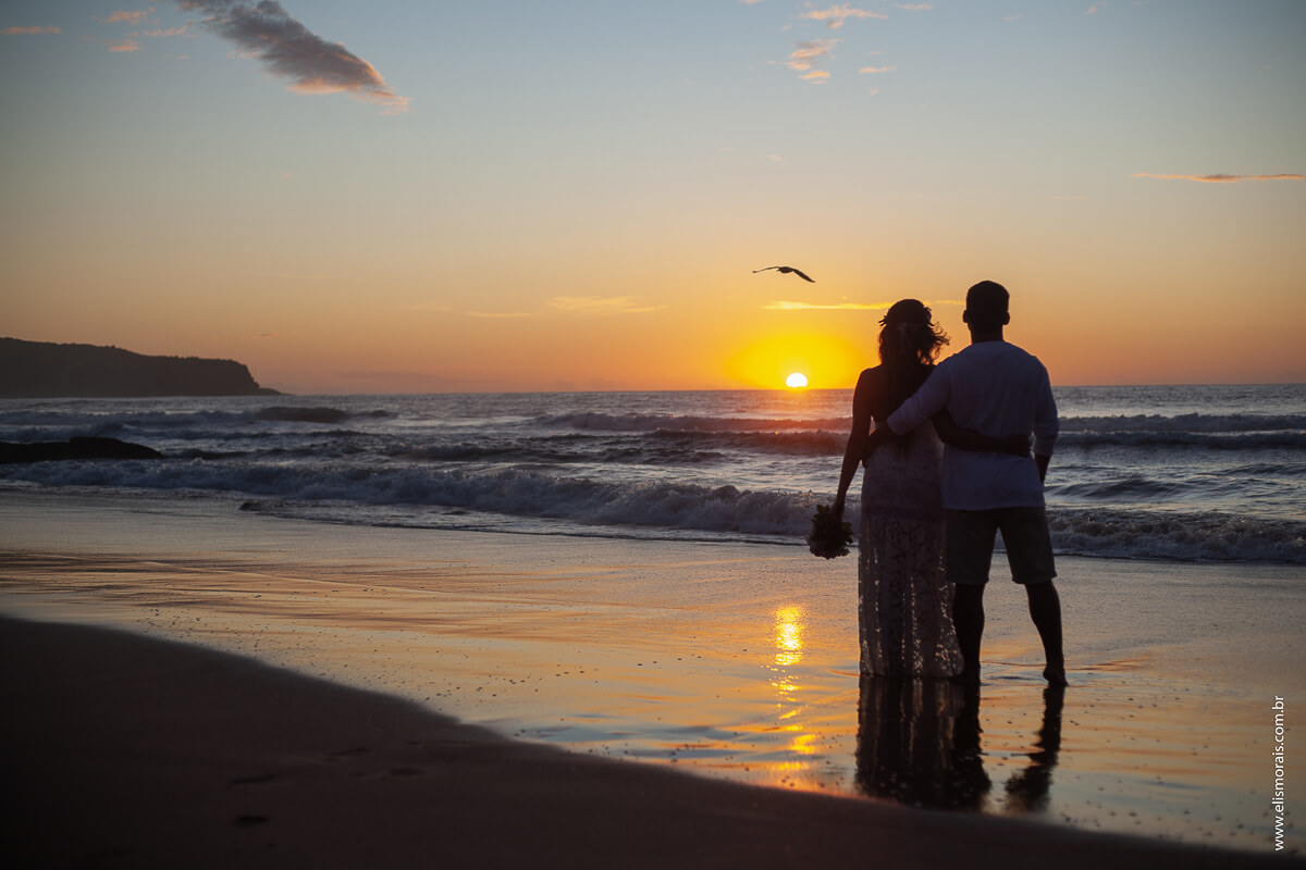 ensaio fotográfico de casal olhando o nascer do sol na Praia de Tucuns em Búzios - RJ