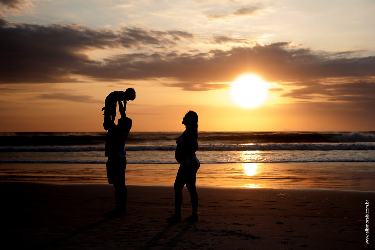foto na contra luz por do sol, ensaio fotográfico gestante na Praia Grande em Arraial do cabo - RJ