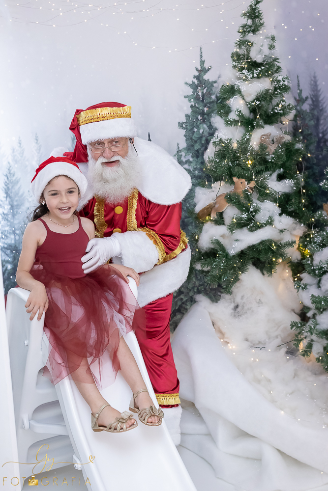 Ensaio de natal em Londrina com papai noel de verdade, cenário interativo com escorregador, neve, lareira e várias árvores maravilhosas. Momento registrado pela fotografa Giscellayne - Gy fotografia. Fotografo em Londrina especializado em ensaios de bebes