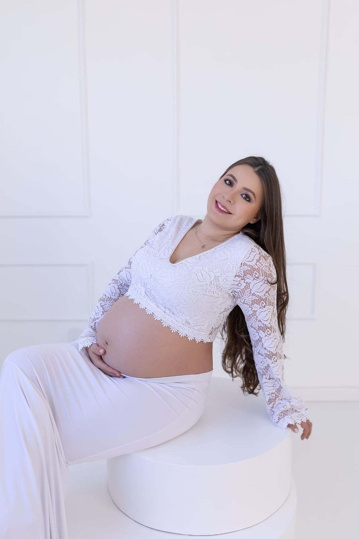 Ensaio de gestante com vestido longo verde e com saia branca, cenários brancos clean com cama e parede de boiserie, fundo branco e muito mais.
Fotógrafa em Londrina especializada em ensaios de gestante. Estúdio Gy fotografia 
