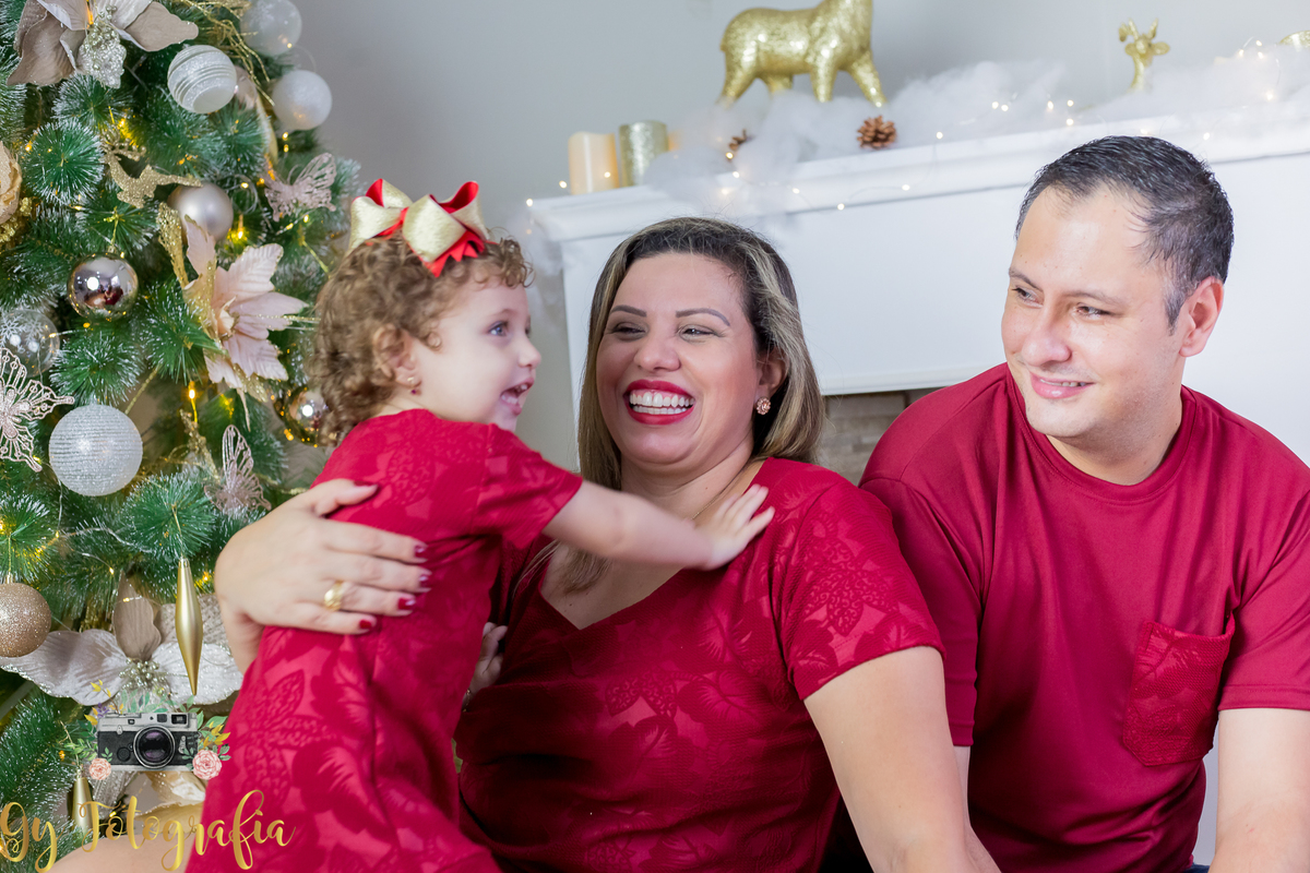 carinho nos pais! Mini ensaio de natal, cenário: lareira. foto com a família no pé da árvore. Fotografo especializado em mini sessões em estúdio, de bebês, crianças e gestantes. Momento registrado pela fotografa Giscellayne | Gy fotografia