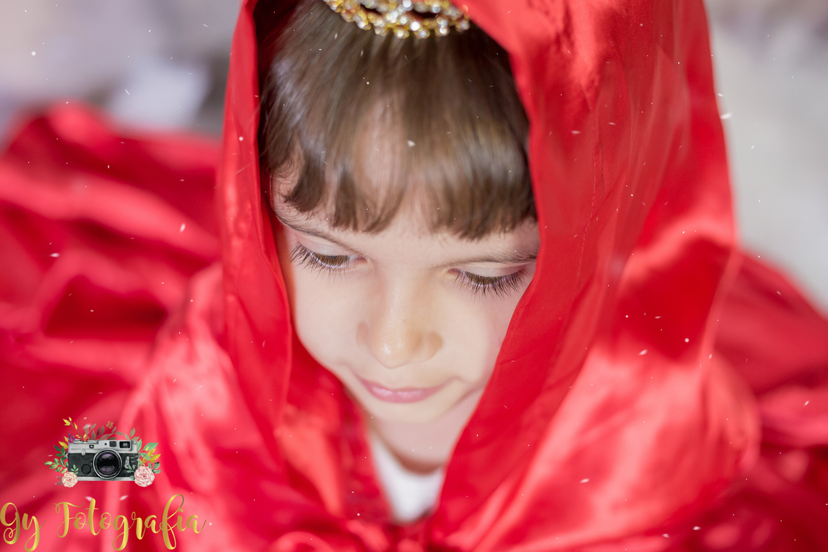 com a capa vermelha toda concentrada!  Mini ensaio de natal e ano novo, fotografo em Londrina. Momento registrado pela fotografa Giscellayne | Gy fotografia, fotógrafa especializada em ensaios de bebes, crianças e gestantes.