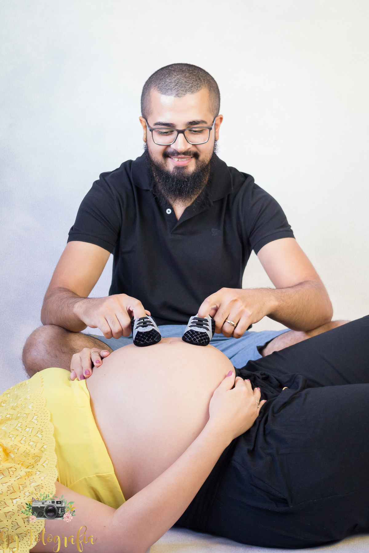 Papai brincando com os sapatinhos na barriga da mamãe! Ensaio de gestante em estúdio em Londrina. Fotografo especializado em ensaios de gestantes. Momento registrado pela fotografa Giscellayne | Gy fotografia!
