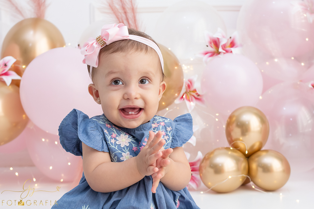 Ensaio smash the cake em estúdio. cenário com balões rosa e plumas. fotógrafo em Londrina especializado em ensaio de bebês e crianças. Ensaio de aniversário. Momento registrado pela fotografa Giscellayne - Gy Fotografia.