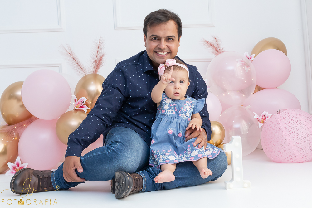 Ensaio smash the cake em estúdio. cenário com balões rosa e plumas. fotógrafo em Londrina especializado em ensaio de bebês e crianças. Ensaio de aniversário. Momento registrado pela fotografa Giscellayne - Gy Fotografia.