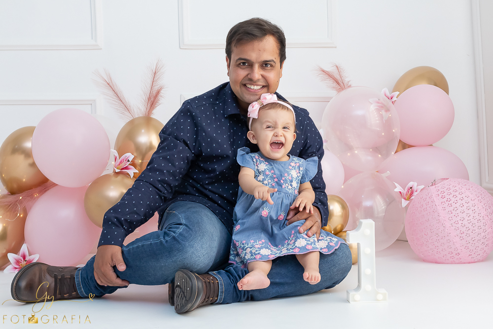 Ensaio smash the cake em estúdio. cenário com balões rosa e plumas. fotógrafo em Londrina especializado em ensaio de bebês e crianças. Ensaio de aniversário. Momento registrado pela fotografa Giscellayne - Gy Fotografia.