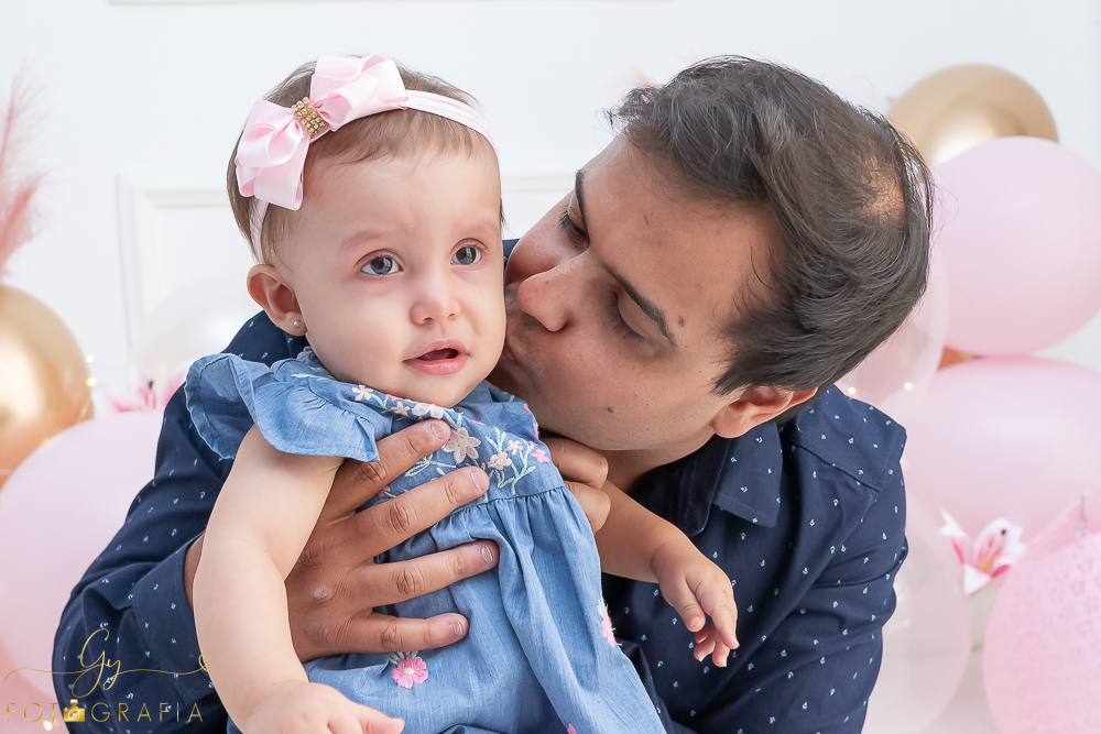 Ensaio smash the cake em estúdio. cenário com balões rosa e plumas. fotógrafo em Londrina especializado em ensaio de bebês e crianças. Ensaio de aniversário. Momento registrado pela fotografa Giscellayne - Gy Fotografia.
