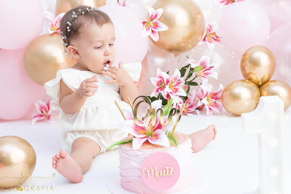 Ensaio smash the cake em estúdio. cenário com balões rosa e plumas. fotógrafo em Londrina especializado em ensaio de bebês e crianças. Ensaio de aniversário. Momento registrado pela fotografa Giscellayne - Gy Fotografia.