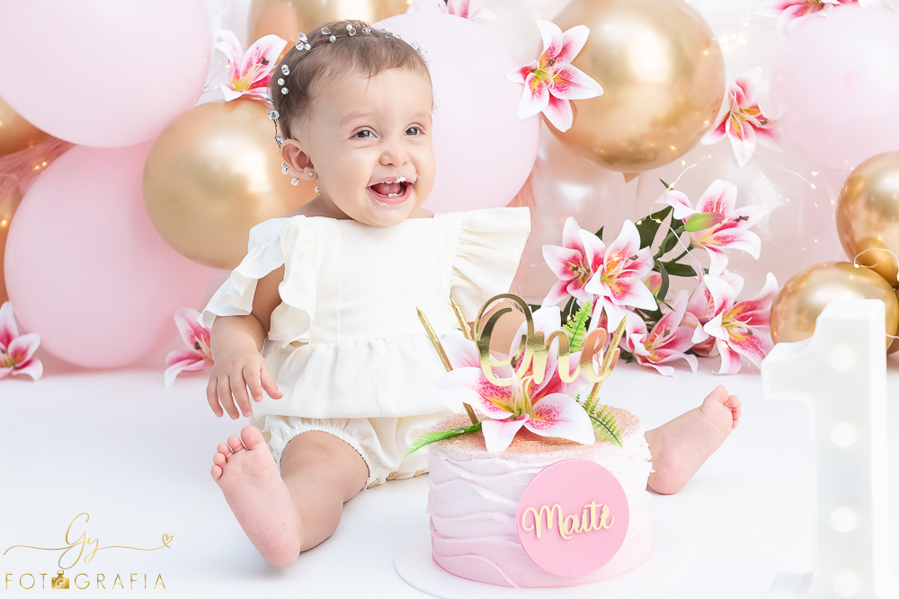 Ensaio smash the cake em estúdio. cenário com balões rosa e plumas. fotógrafo em Londrina especializado em ensaio de bebês e crianças. Ensaio de aniversário. Momento registrado pela fotografa Giscellayne - Gy Fotografia.