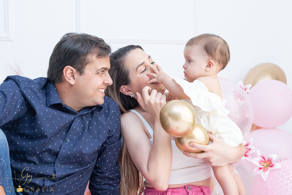 Ensaio smash the cake em estúdio. cenário com balões rosa e plumas. fotógrafo em Londrina especializado em ensaio de bebês e crianças. Ensaio de aniversário. Momento registrado pela fotografa Giscellayne - Gy Fotografia.