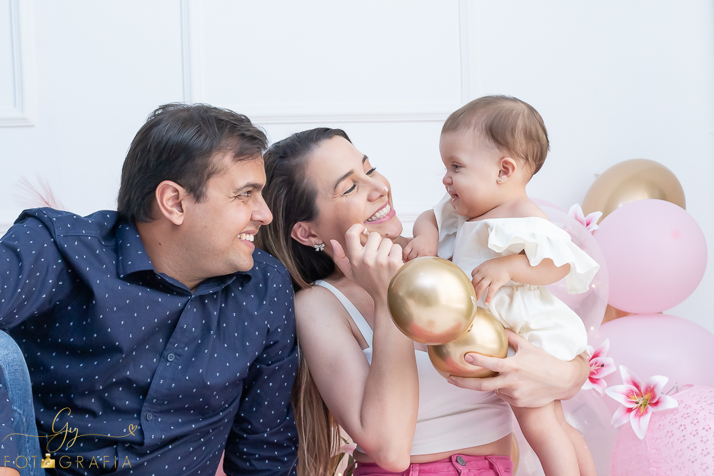 Ensaio smash the cake em estúdio. cenário com balões rosa e plumas. fotógrafo em Londrina especializado em ensaio de bebês e crianças. Ensaio de aniversário. Momento registrado pela fotografa Giscellayne - Gy Fotografia.