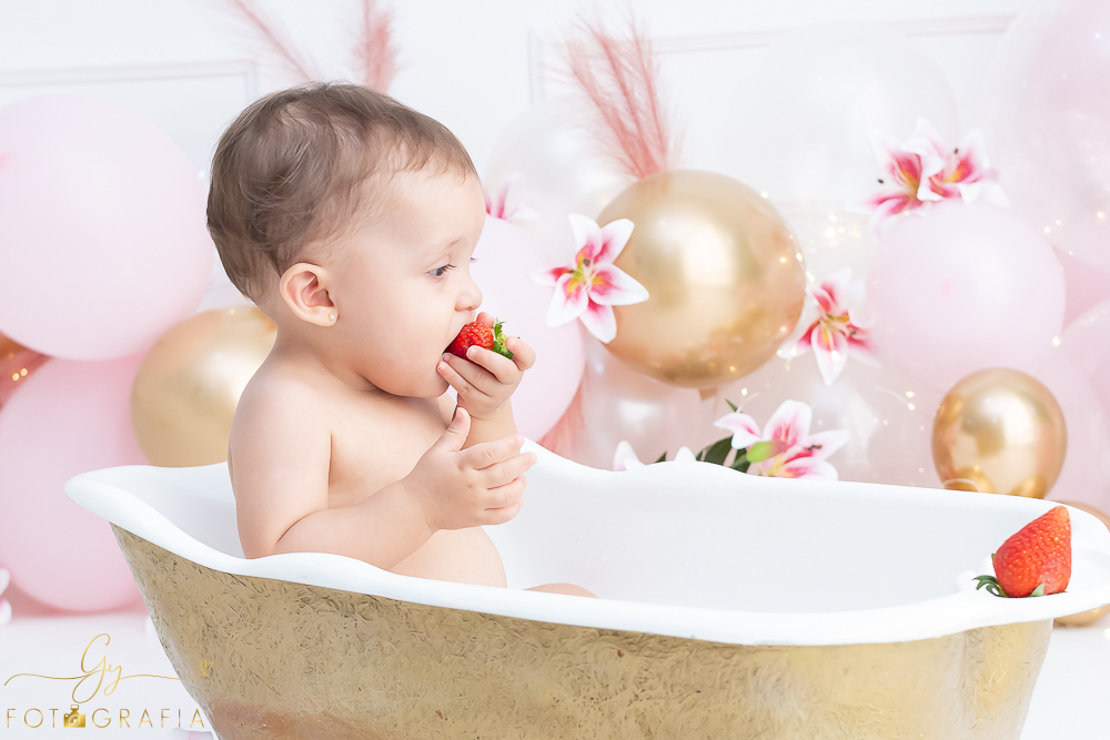 Ensaio smash the cake em estúdio. cenário com balões rosa e plumas. fotógrafo em Londrina especializado em ensaio de bebês e crianças. Ensaio de aniversário. Momento registrado pela fotografa Giscellayne - Gy Fotografia.
