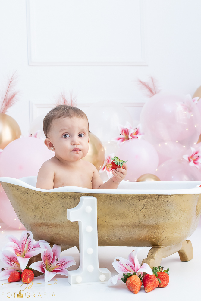 Ensaio smash the cake em estúdio. cenário com balões rosa e plumas. fotógrafo em Londrina especializado em ensaio de bebês e crianças. Ensaio de aniversário. Momento registrado pela fotografa Giscellayne - Gy Fotografia.