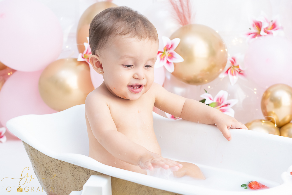 Ensaio smash the cake em estúdio. cenário com balões rosa e plumas. fotógrafo em Londrina especializado em ensaio de bebês e crianças. Ensaio de aniversário. Momento registrado pela fotografa Giscellayne - Gy Fotografia.