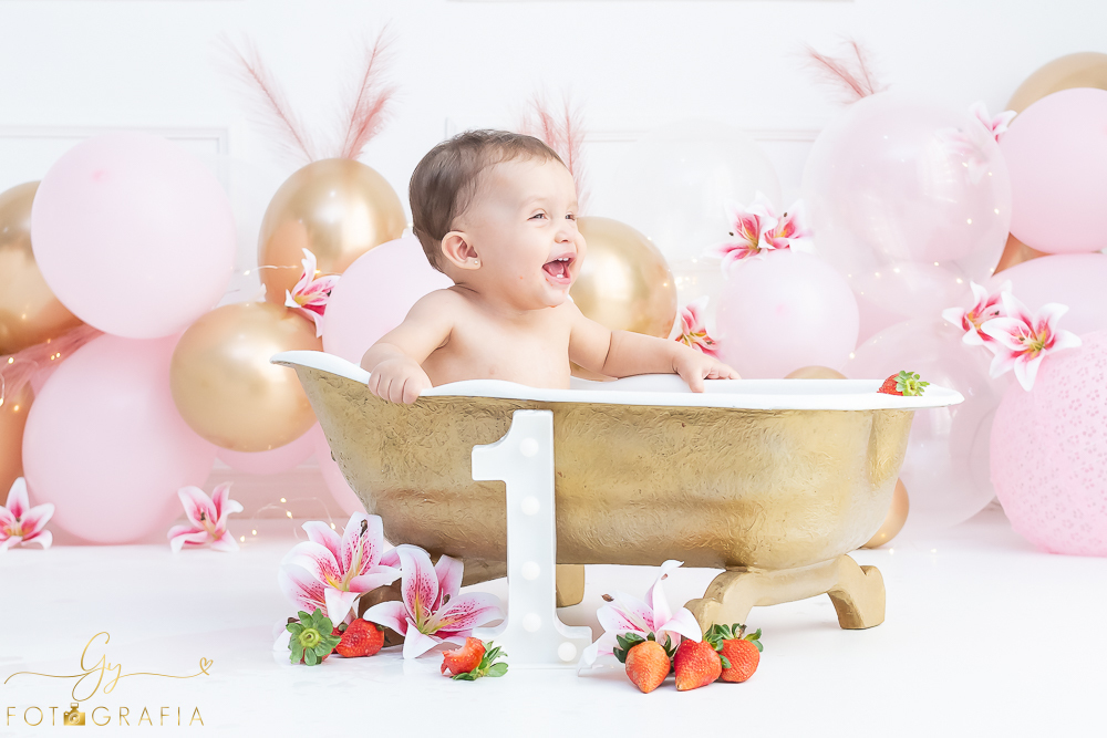 Ensaio smash the cake em estúdio. cenário com balões rosa e plumas. fotógrafo em Londrina especializado em ensaio de bebês e crianças. Ensaio de aniversário. Momento registrado pela fotografa Giscellayne - Gy Fotografia.