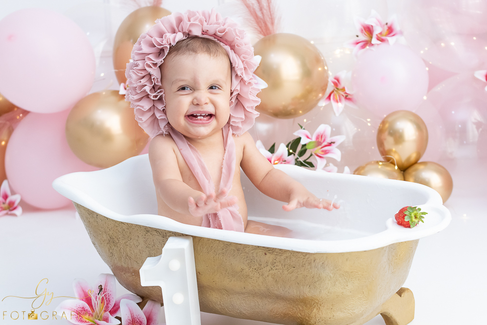Ensaio smash the cake em estúdio. cenário com balões rosa e plumas. fotógrafo em Londrina especializado em ensaio de bebês e crianças. Ensaio de aniversário. Momento registrado pela fotografa Giscellayne - Gy Fotografia.