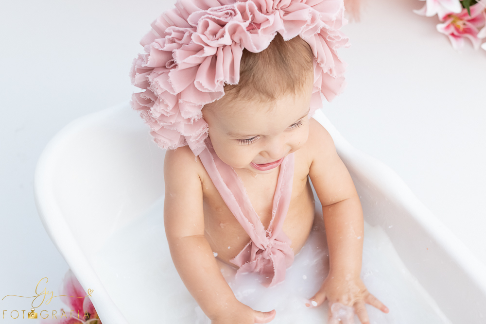 Ensaio smash the cake em estúdio. cenário com balões rosa e plumas. fotógrafo em Londrina especializado em ensaio de bebês e crianças. Ensaio de aniversário. Momento registrado pela fotografa Giscellayne - Gy Fotografia.