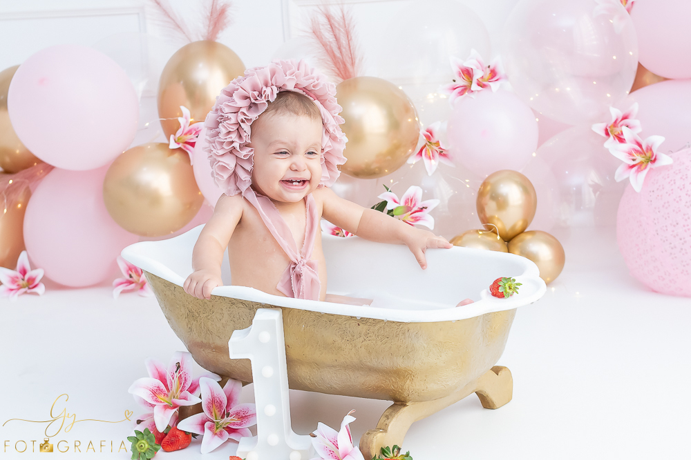 Ensaio smash the cake em estúdio. cenário com balões rosa e plumas. fotógrafo em Londrina especializado em ensaio de bebês e crianças. Ensaio de aniversário. Momento registrado pela fotografa Giscellayne - Gy Fotografia.