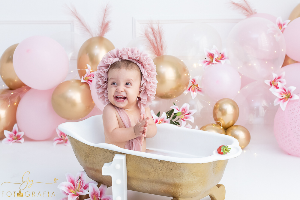 Ensaio smash the cake em estúdio. cenário com balões rosa e plumas. fotógrafo em Londrina especializado em ensaio de bebês e crianças. Ensaio de aniversário. Momento registrado pela fotografa Giscellayne - Gy Fotografia.