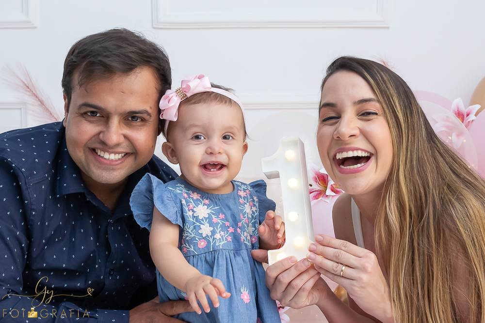 Ensaio smash the cake em estúdio. cenário com balões rosa e plumas. fotógrafo em Londrina especializado em ensaio de bebês e crianças. Ensaio de aniversário. Momento registrado pela fotografa Giscellayne - Gy Fotografia.