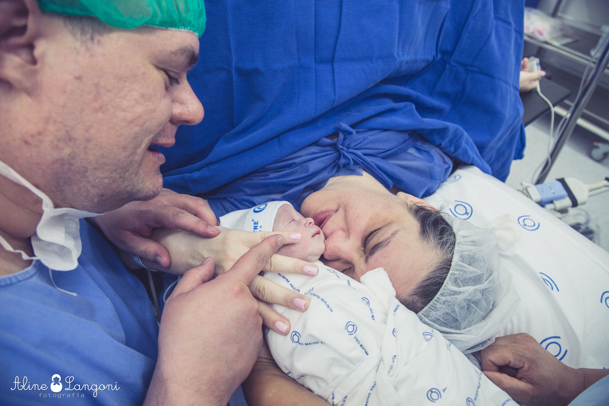 pais beijando o recém nascido