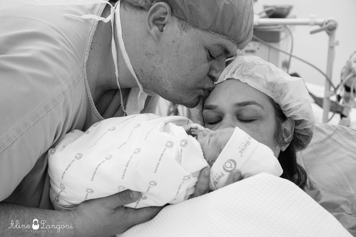 pai beija a mamãe e recém nascido